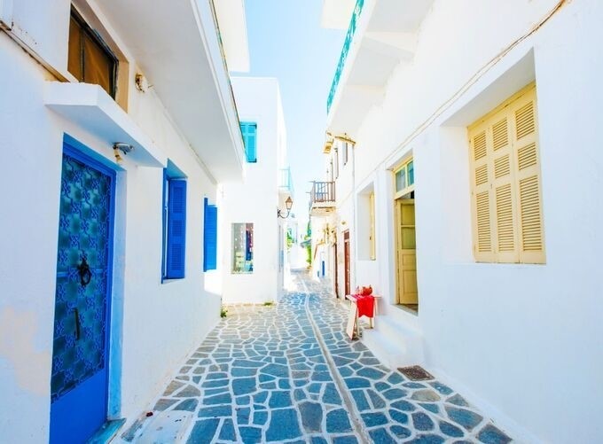 Couple walking hand-in-hand through Mykonos’ picturesque narrow streets