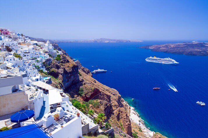 Santorini’s windmills stand tall against dazzling Mediterranean sunset skies.