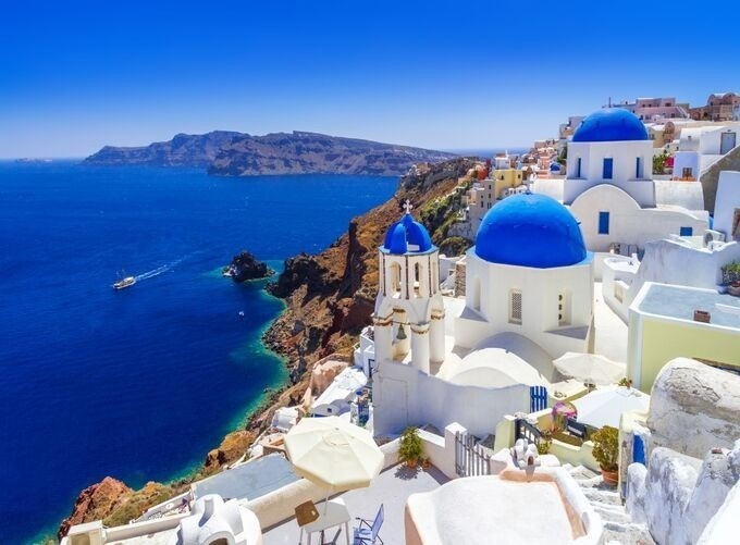 Santorini’s iconic churches perched on cliffs above sparkling Aegean Sea