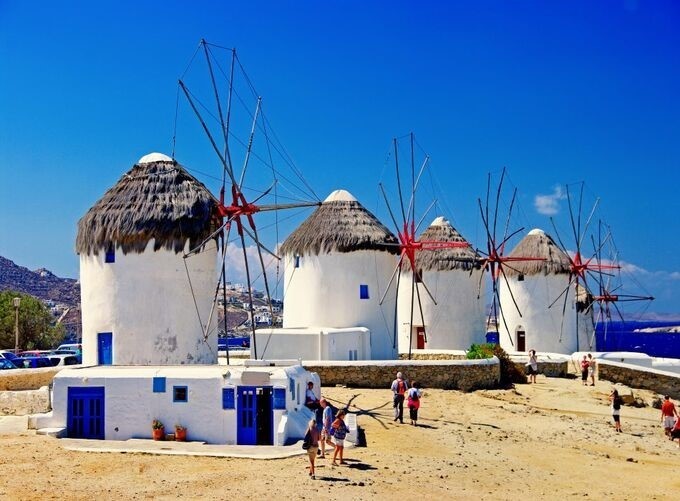 Iconic Mykonos windmills perched above Little Venice and shimmering sea