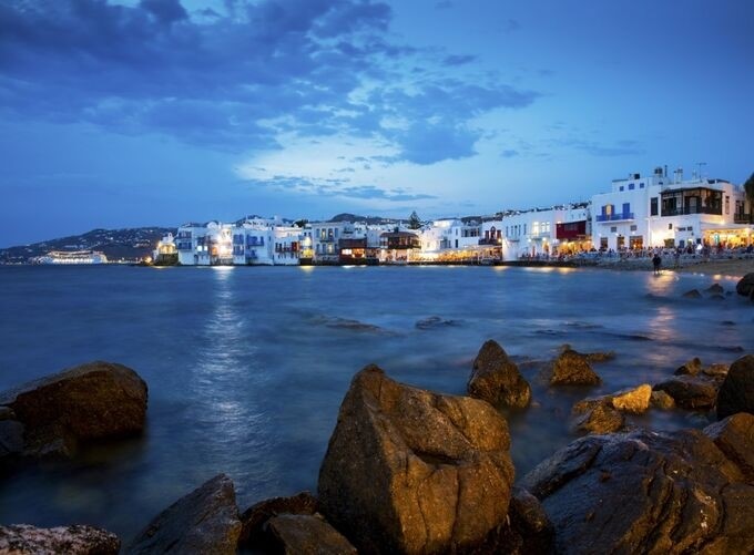 Evening in Mykonos with glowing lights and peaceful waterfront views