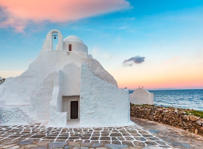 Beachside loungers on a serene Mykonos shoreline with clear waters