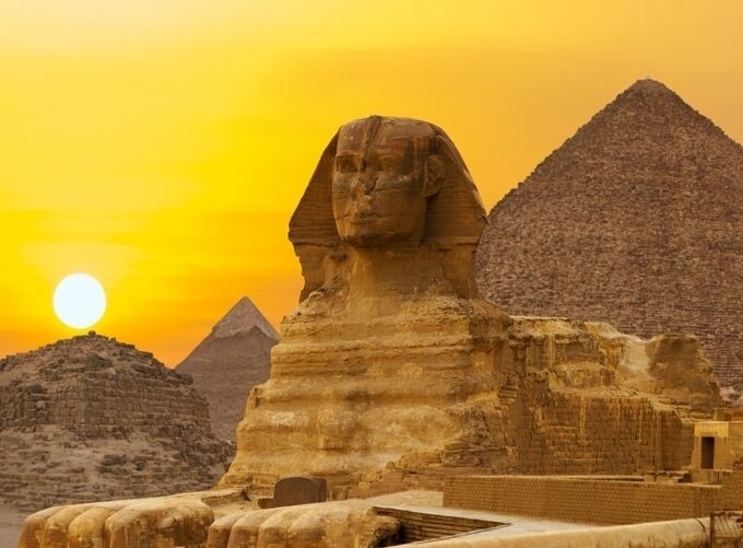 Tourists exploring the Great Pyramid of Giza in golden light