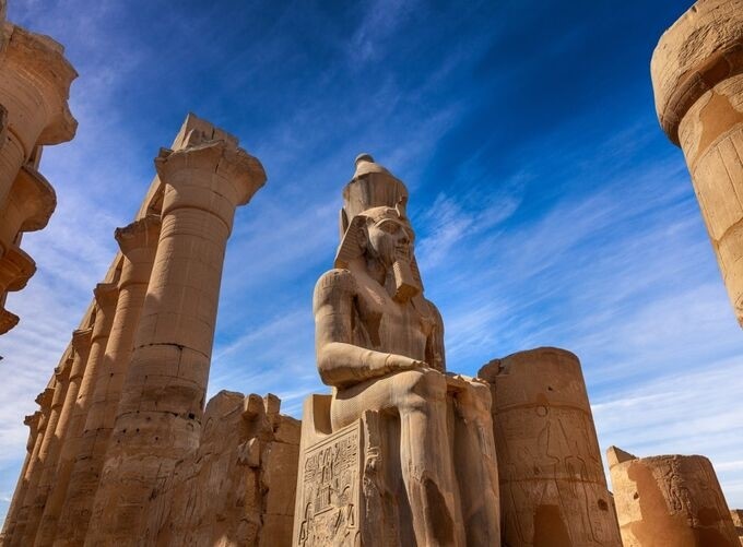 Luxor Temple illuminated by golden light under clear blue skies